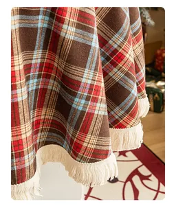 Close-up of vintage red and green plaid tablecloth with decorative cream tassel edges