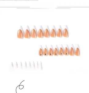 Detailed view of long coffin French nails in nude pink with white tips and tiny rhinestones