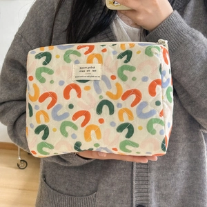 Quilted cotton makeup bag with colorful U-pattern and woven label detail close-up