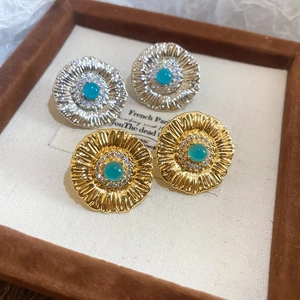 Detailed view of vintage flower earrings with turquoise stones in gold and silver