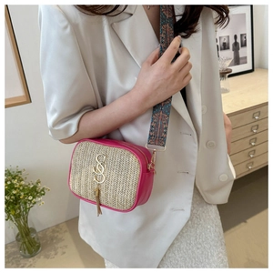 Detail of woven straw and pink leather camera bag with colorful strap and SS logo