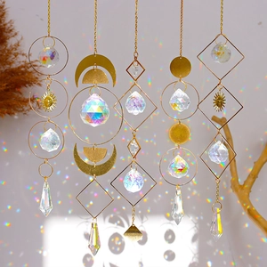Detail of crystal suncatchers casting rainbow light spots with gold metal moon and sun accents