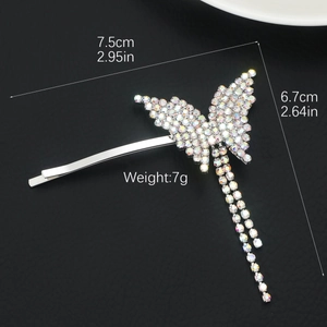 Silver butterfly hair clip with colorful rhinestones and tassels on a black background