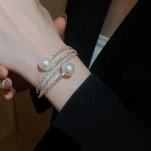 Detail of multi-layer silver bangle with sparkling rhinestones and large white pearls