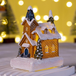 Detail of LED Christmas church with warm light and sparkling snow-covered roof