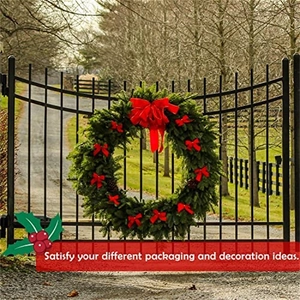 Christmas wreath with red velvet bows and gold edges on a garden gate decoration