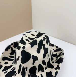 Detailed close-up of the black and white cow print pattern on a wool felt cowboy hat