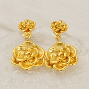 Détail macro de boucles d'oreilles rose en acier inoxydable plaqué or 18 carats à pétales