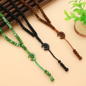 Detail of 99 Muslim prayer beads with resin star and crescent charms and tassels
