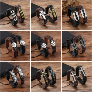 Retro braided leather bracelets for men featuring cross and sports charms on wooden background