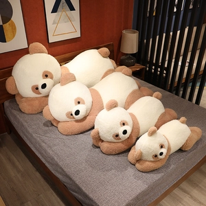 Panda en peluche allongé en plusieurs tailles sur un lit avec un tissu doux crème et marron