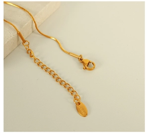 Detail of gold stainless steel necklace with lobster clasp, adjustment chain and S.steel tag