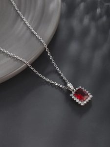 Detail of red emerald-cut zircon necklace pendant with silver metal setting and chain
