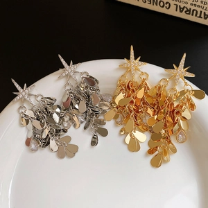 Vue macro de boucles d'oreilles étoiles dorées et argentées avec franges en métal