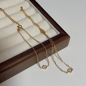 Detail of 18k gold plated bracelets with zircon inlay and lobster clasp on jewelry tray