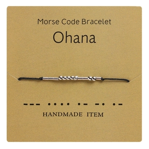 Detail of Morse code bracelet on kraft card with Ohana meaning and black woven rope