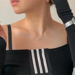Detail of 925 sterling silver necklace showing a symbolic handshake pendant on a model