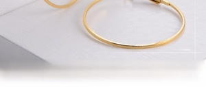 Macro shot of 18k gold plated hoop earrings featuring fine textured mesh engraving