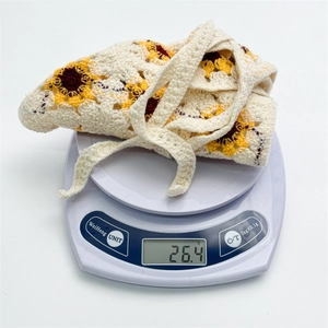 Detailed weight measurement showing 26.4g for the floral crochet headscarf on digital scale