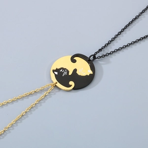 Détail de pendentifs chats noirs et dorés entrelacés sur des colliers en acier inoxydable