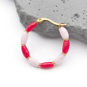 Detail of bamboo joint earrings with red and pink enamel beads and gold plating
