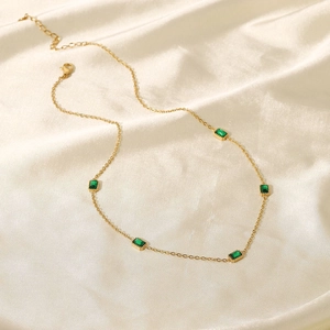 Vue détaillée du collier en acier inoxydable doré 14K avec cinq zircons verts sur soie