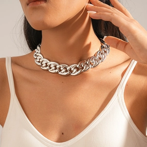 Close-up of chunky silver Cuban chain necklace worn by a model in soft studio lighting