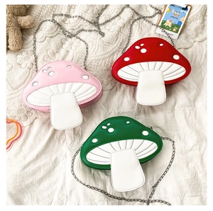 Detailed view of mushroom-shaped crossbody bags in red pink and green faux leather