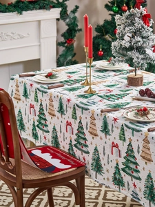Close-up of festive Christmas tablecloth and red chair covers with tree patterns
