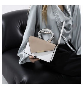 Detail of two-tone beige handbag with unique silver irregular liquid metal top handle