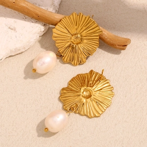 Dettaglio di orecchini a fiore placcati oro 18K con perle ovali bianche eleganti