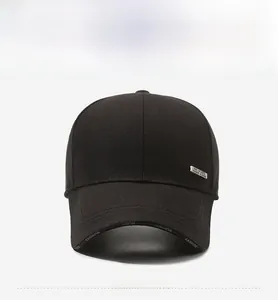 Detail of black baseball cap showing metal logo tag and printed brim lettering