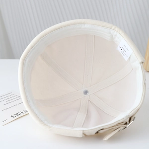 Détail de l'intérieur du bonnet docker beige avec bandeau et boucle métallique réglable