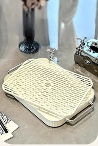 Close-up of cream-colored rectangular double-layer drainage tray with silver rabbit handles