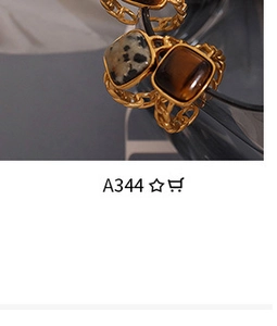 Close-up of golden braided ring featuring square black-white spotted and brown gemstones