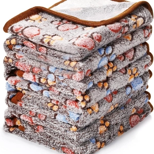 Stack of soft flannel pet blankets with colorful paw prints and reinforced brown edges