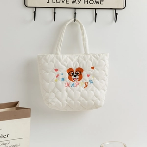 Detail of white quilted lunch bag with cute heart pattern and dog head embroidery