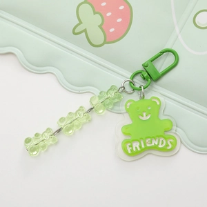 Macro shot of green acrylic gummy bear keychain with white FRIENDS text and chain