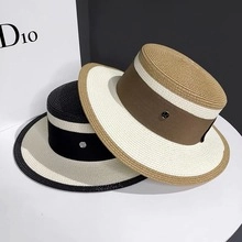Detail of woven straw boater hats with wide ribbons and elegant metallic button accents