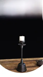 Detailed view of vintage cast iron candle holder on rustic dark wooden table surface