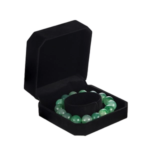 Detail view of a black velvet jewelry box with a green jade bead bracelet inside