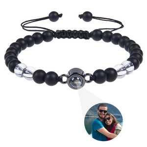 Detail of custom photo projection bracelet with matte black beads and braided cord