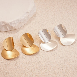 Geometrical oval metal earrings in gold and silver finish with brushed texture
