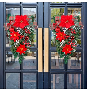 Dual Christmas teardrop swags with red poinsettias and plaid bows on black glass doors