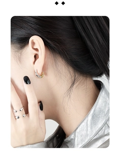Detail view of a minimalist silver and gold two-tone ear cuff and a double-row ring