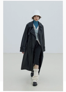Detailaufnahme von schwarzem Kunstleder-Trenchcoat mit zweireihigen Knöpfen und Revers