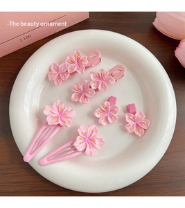 Set of 6 pink cherry blossom hair clips including BB clips and grips on a plate