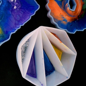 Macro view of multi-slot silicone mixing cup with vibrant resin colors and glitters