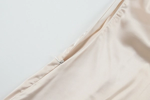 Nahaufnahme eines nahtlosen Reißverschlusses an einem rückenfreien Satin-Maxikleid