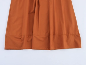 Détail de l'ourlet de la robe chemise en popeline caramel avec coutures soignées